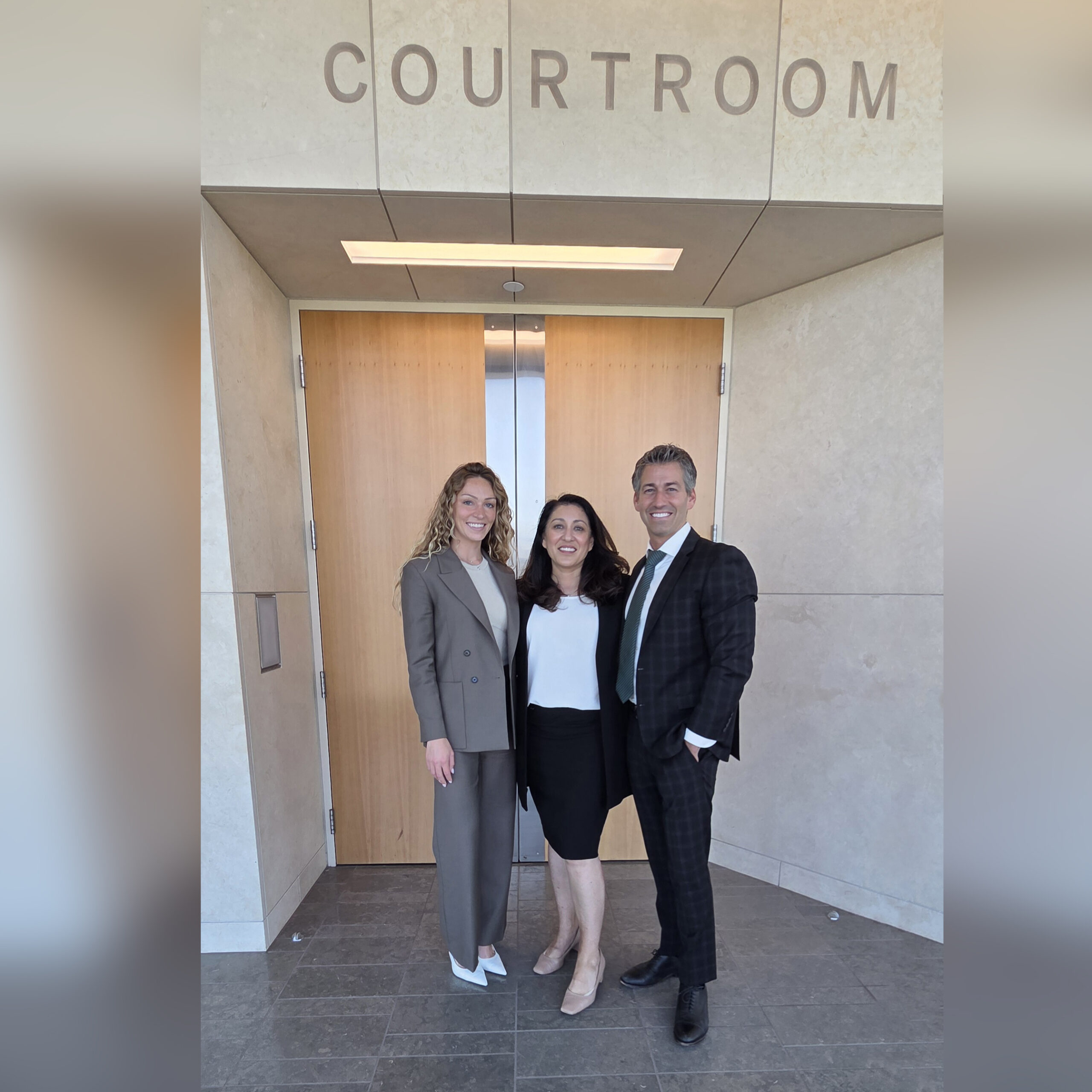 Photo of Abby Morelli, Bernadette Brouses and Jonathan Gerber outside of courtroom April May 2026